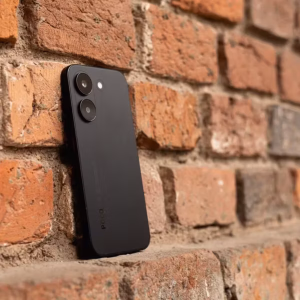 Черный смартфон POCO X8 Pro с двумя камерами на задней панели у кирпичной стены