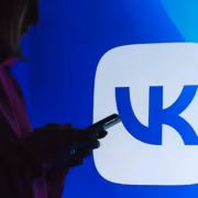 Человек использует смартфон на фоне логотипа Яндекс.Дзена