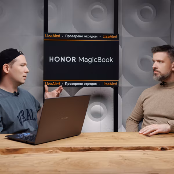 Два мужчины за столом рядом с ноутбуком HONOR MagicBook