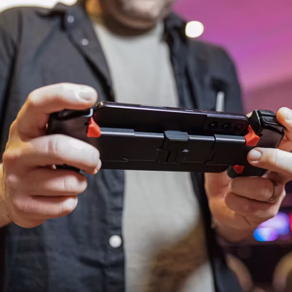 Человек держит игровой смартфон OnePlus с геймпадом
