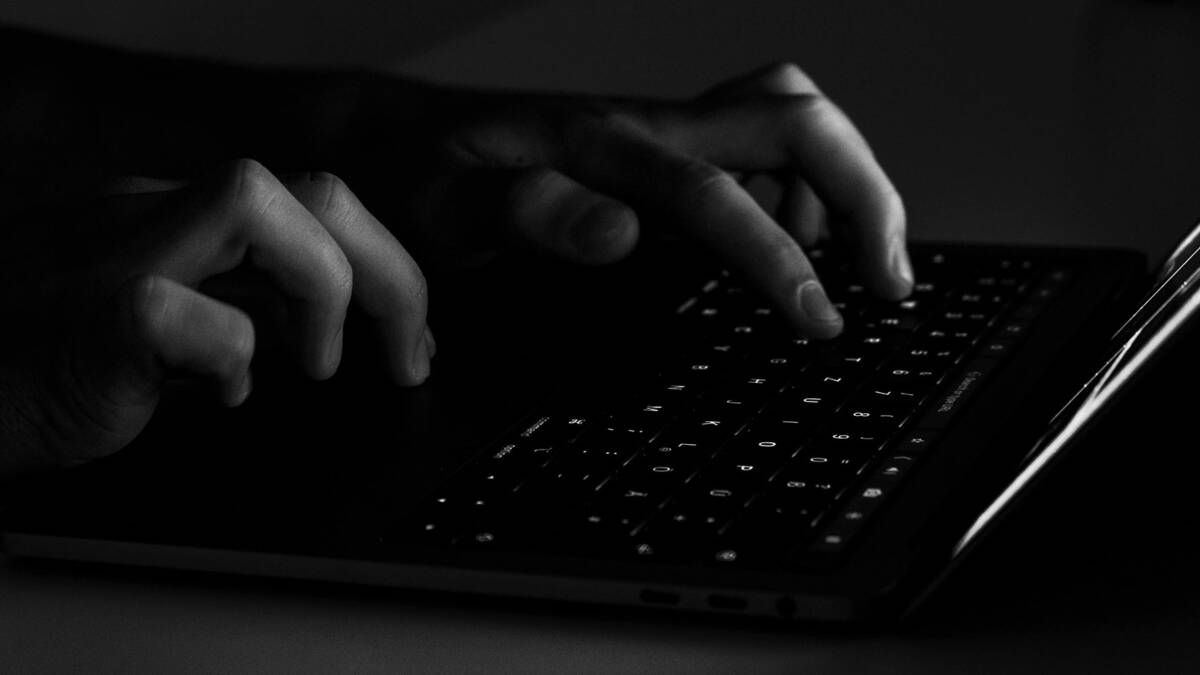 человек печатает на клавиатуре MacBook с подсветкой