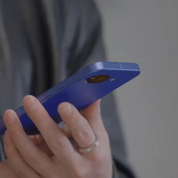 Человек держит синий смартфон Google Pixel 10a