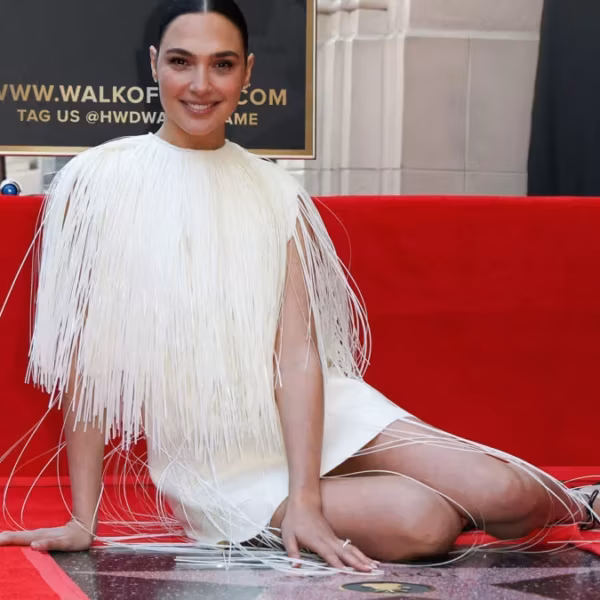 женщина в белом платье с длинными бахромчатыми деталями на улице