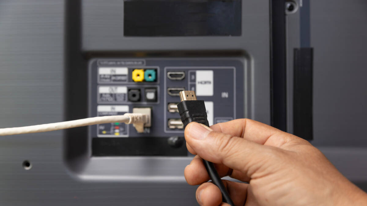 5 гаджетов для телевизора с HDMI 2.0 1 человек подключает HDMI кабель к разъёму телевизора