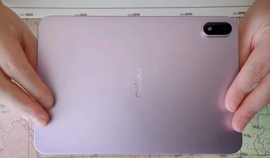 Карта и рука держат телефон Oppo Pad Mini на поверхности