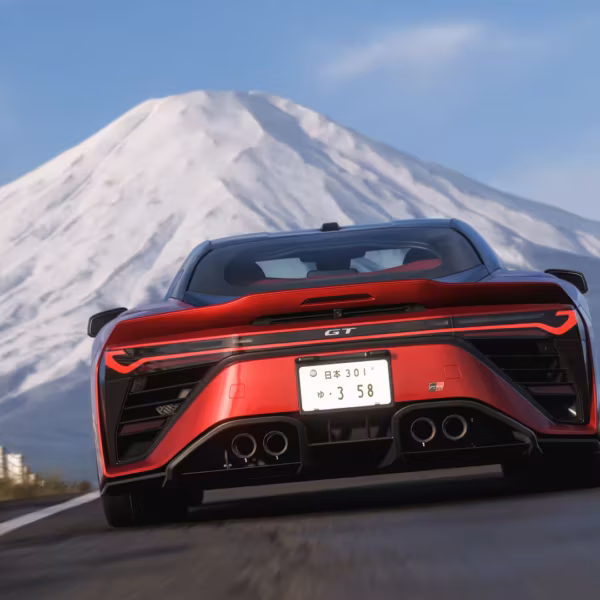 Красный спорткар GT на дороге с горой в фоне