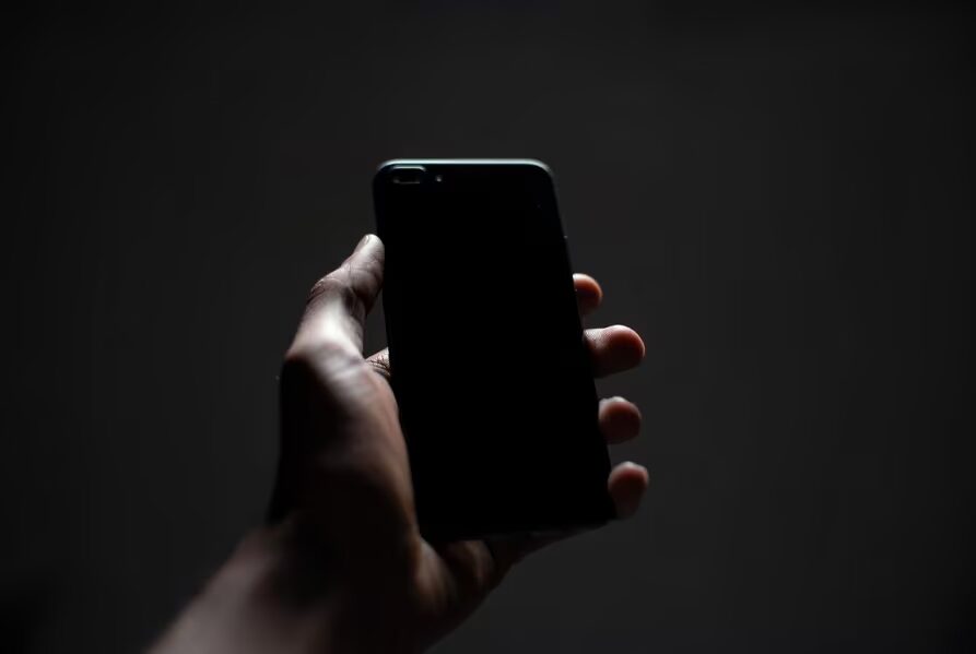 Человек держит смартфон Huawei Mate 90 в темной среде