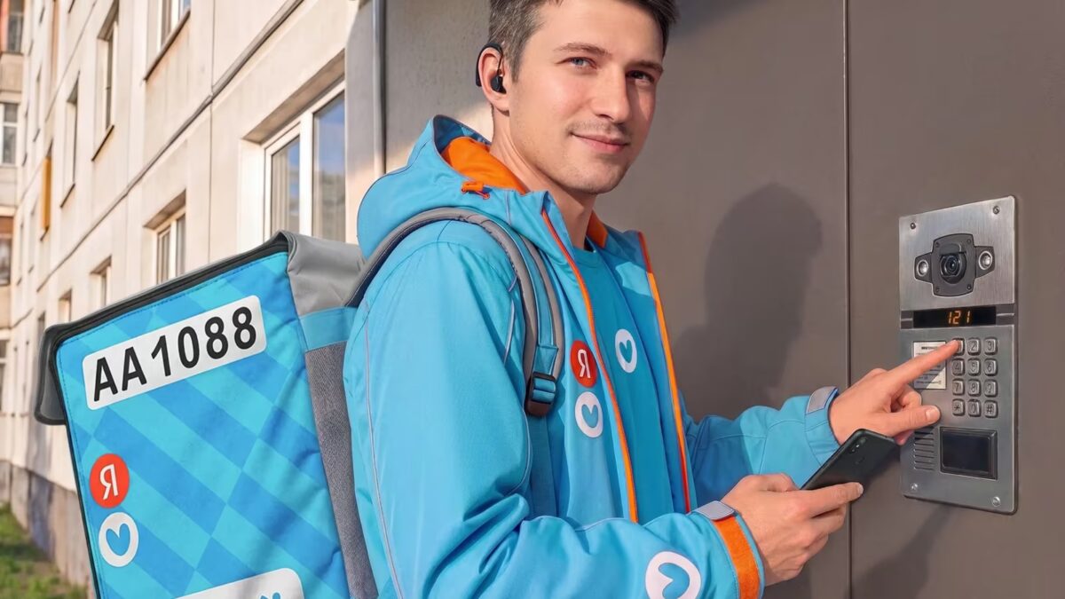 Глухой курьер Яндекс Лавка в кепке подьезжает к видеодомофону