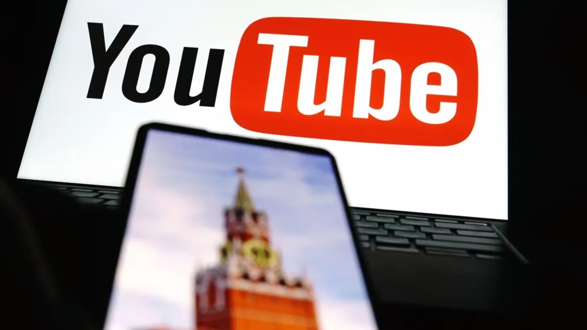 экран ноутбука с логотипом YouTube и смартфон с изображением Кремля