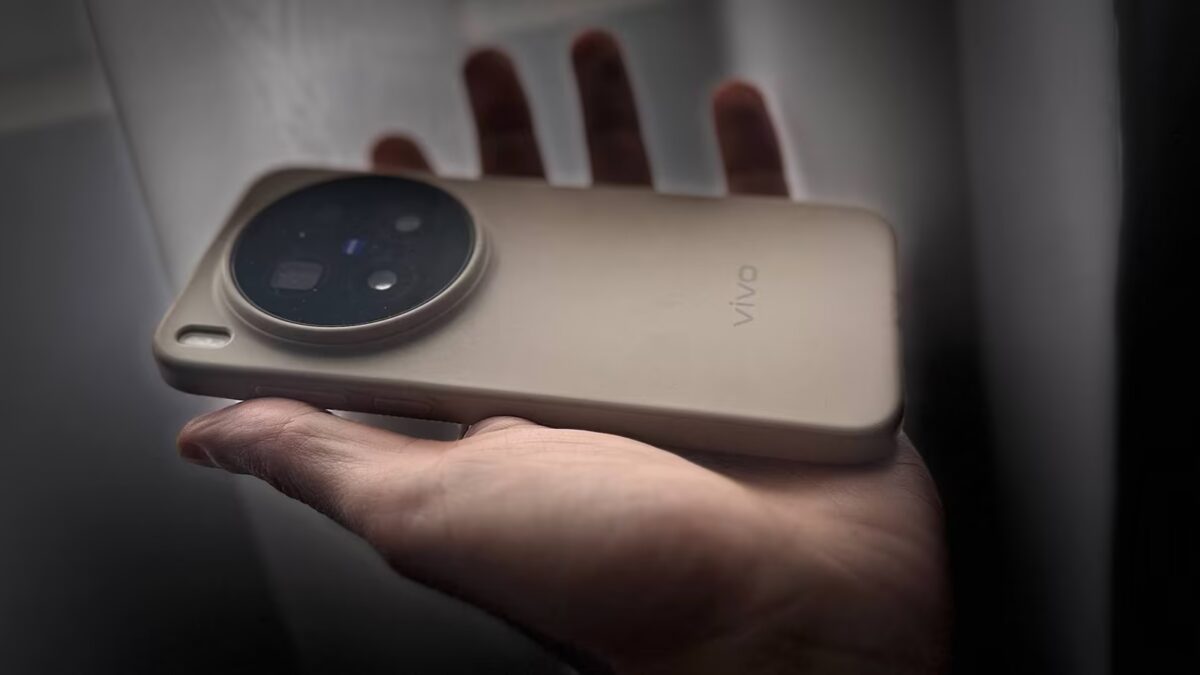 Мужчина держит Vivo X500 смартфон в руке