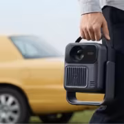Человек держит портативный проекционный экран Wanbo ToGo Pro и Cube 1