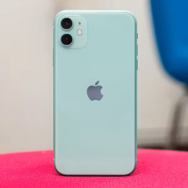 Зеленый iPhone 11 на розовой ткани сзади