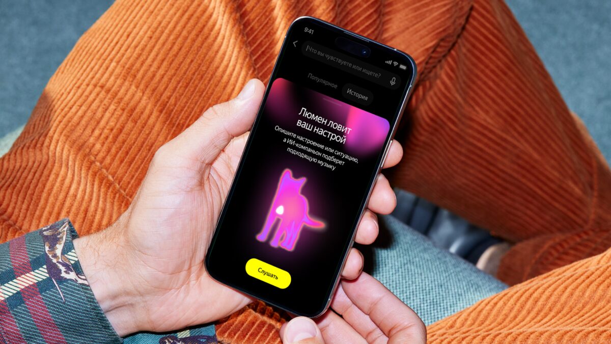 Человек держит iPhone с приложением Яндекс Музыка