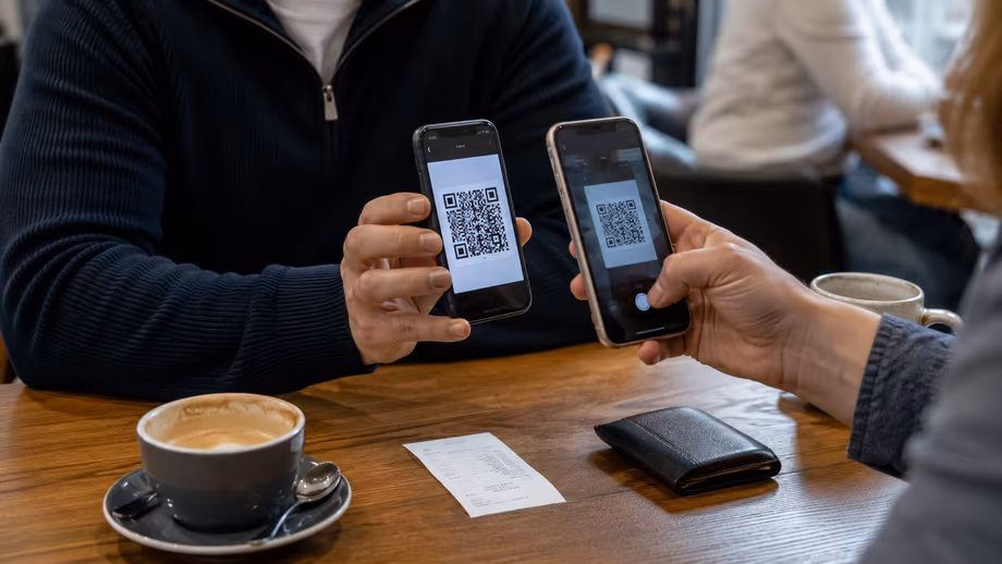 Два телефона показывают QR-код для перевода через ВТБ СБП
