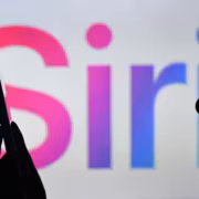 силуэт человека держит смартфон перед экраном Apple Siri AI