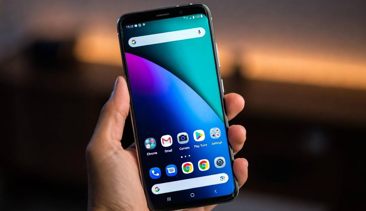 Смартфон Samsung Galaxy S21 на руке в темноте