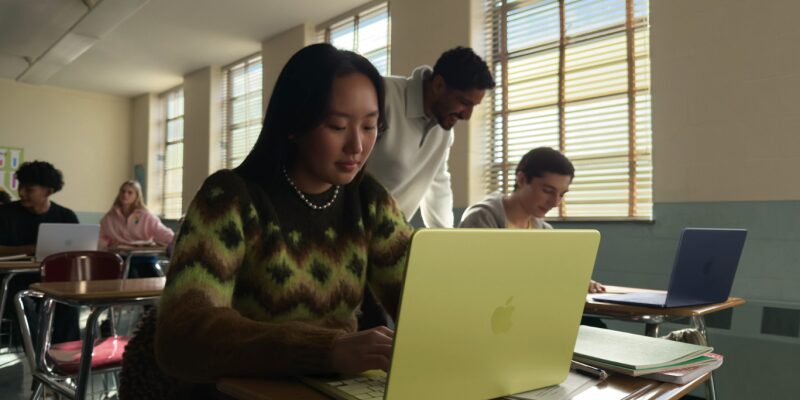 Студентка работает за ноутбуком Apple в классе