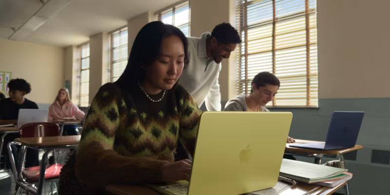 Студентка работает за ноутбуком Apple в классе