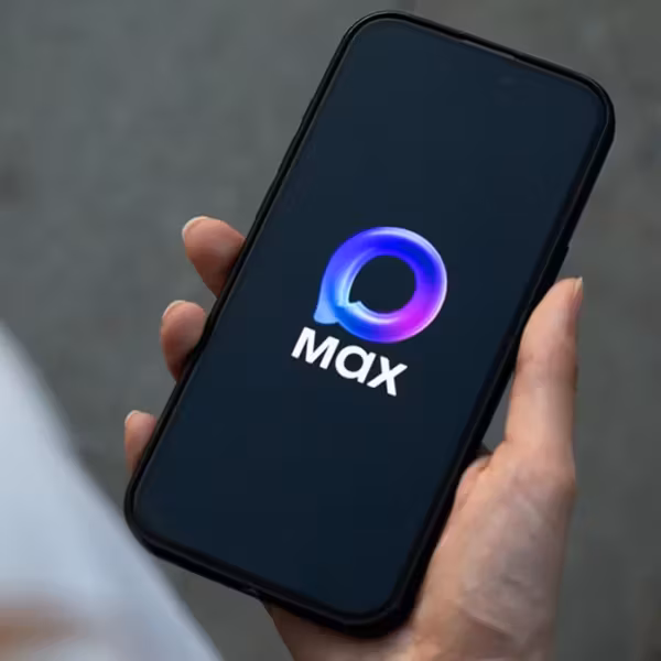 Человек держит телефон с логотипом Max на экране