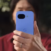 Женщина держа смартфон Google Pixel 6a на улице