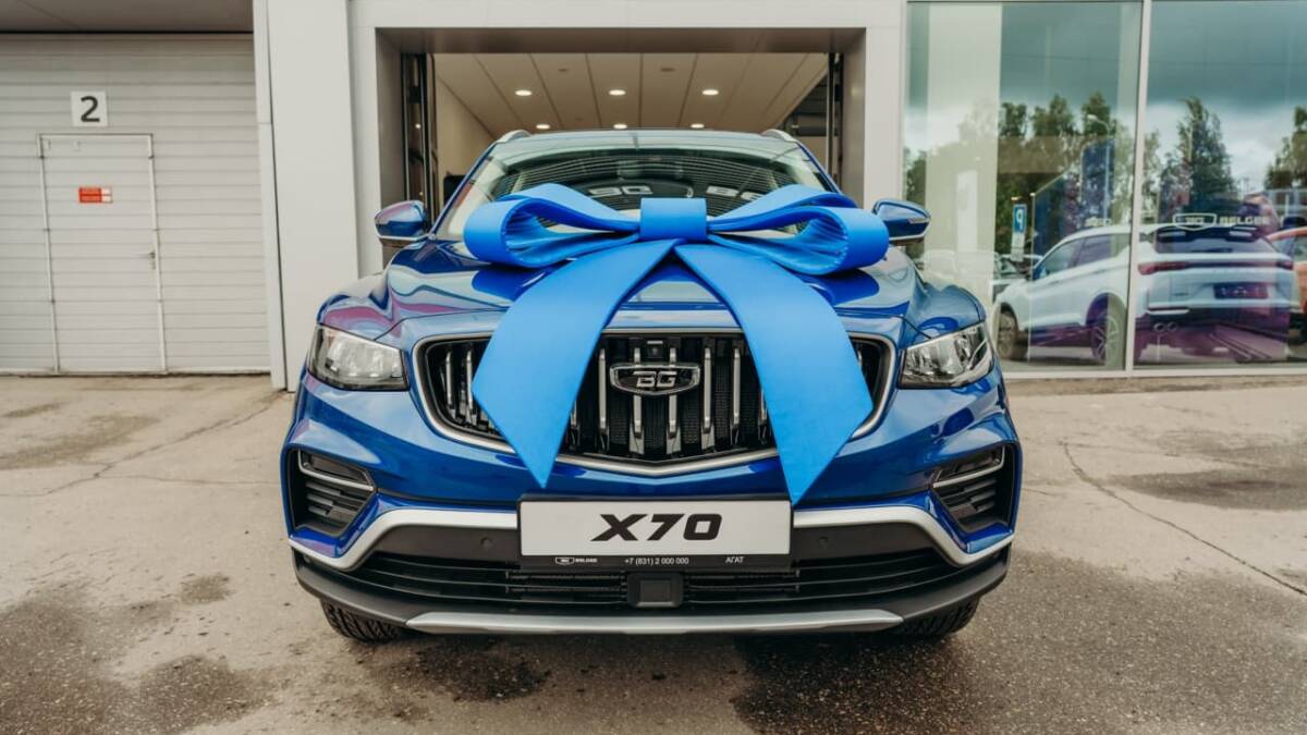 синяя машина Geely X70 с большим синим бантом