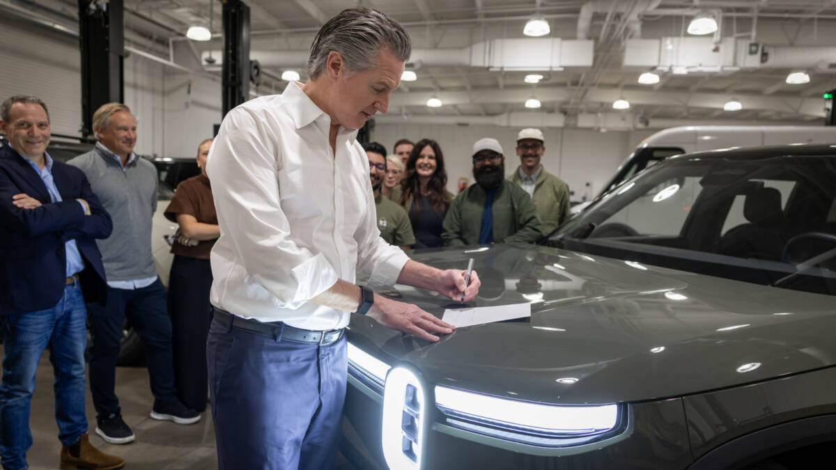 Человек подписывает документ у электромобиля Cadillac Lyriq