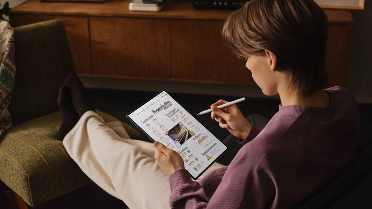 Человек использует планшет Huawei MatePad Pro Max на диване