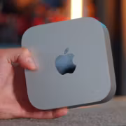 Человек держит Mac mini новейшую модель на руке