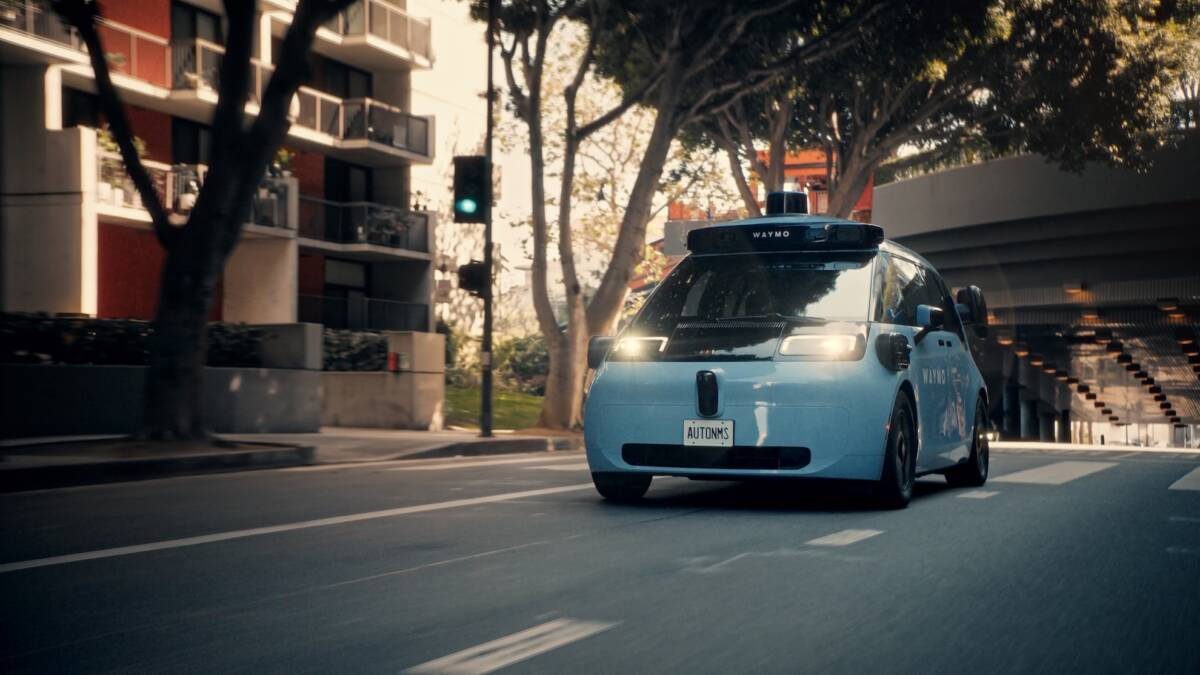 Автомобиль Waymo роботакси на улице с зелёным светом