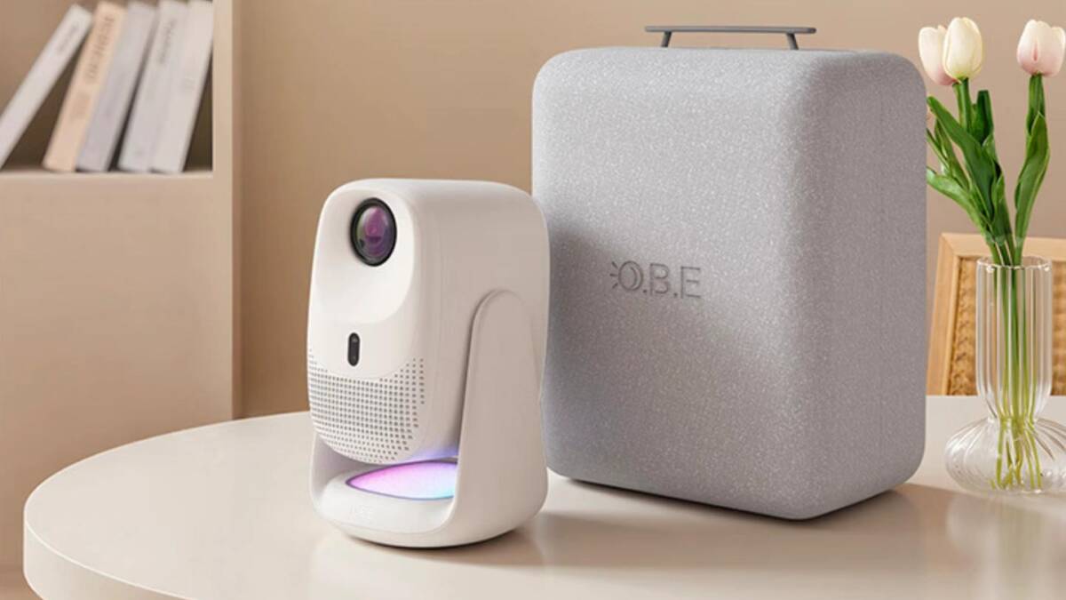 Проектор Dangbei C5 Pro на столе с книгами и цветами