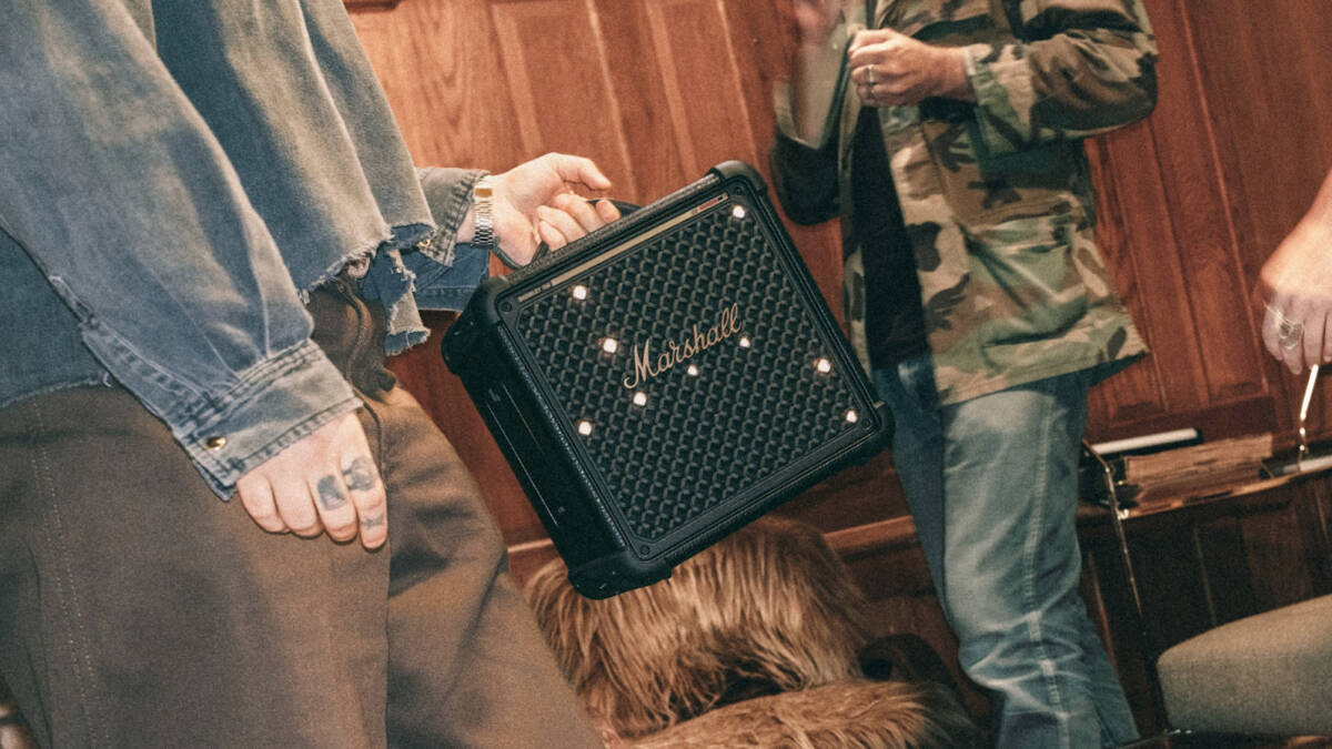 Человек держит портативную колонку Marshall на руке