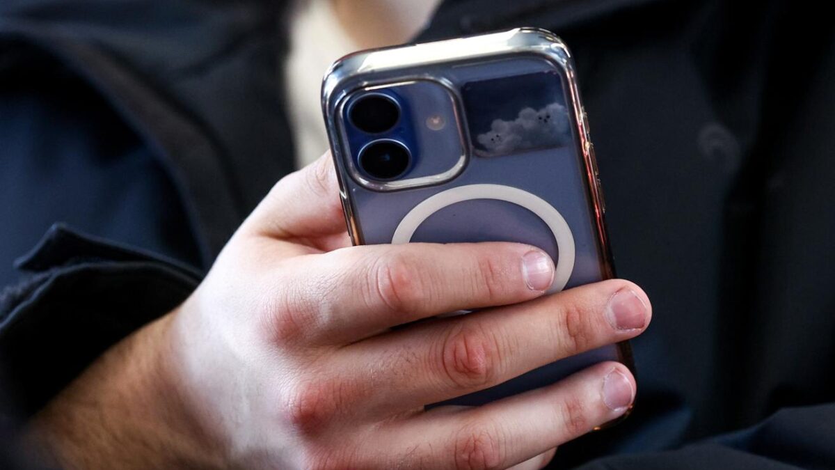 Человек держит iPhone с прозрачным чехлом и кольцом