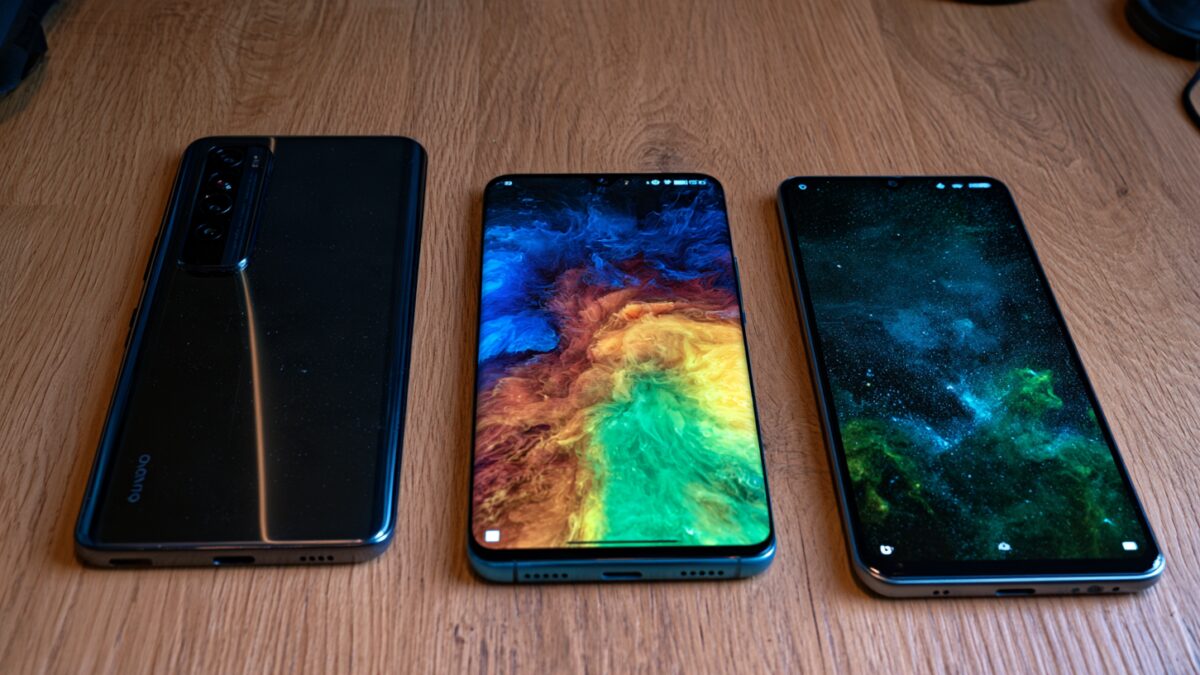 Три смартфона vivo Y600 5G лежат на деревянном столе